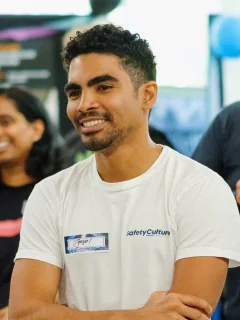 Jason Hindley at SafetyCulture, smiling with his arms crossed, in a SafetyCulture T-shirt.
